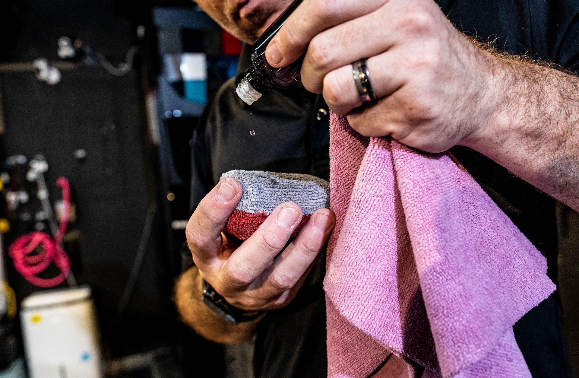 A man is holding a pink towel in his hands.